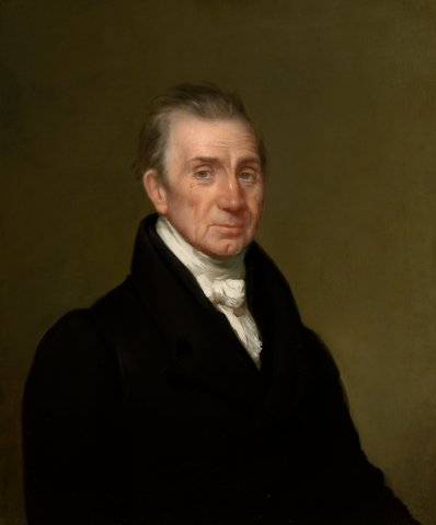 Waist length, ¾ view of a middle-aged man in a black coat with a white tie and jabot.