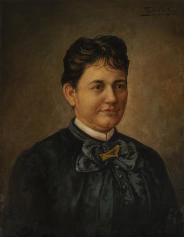 Bust length portrait of a woman in a black dress with black hair.